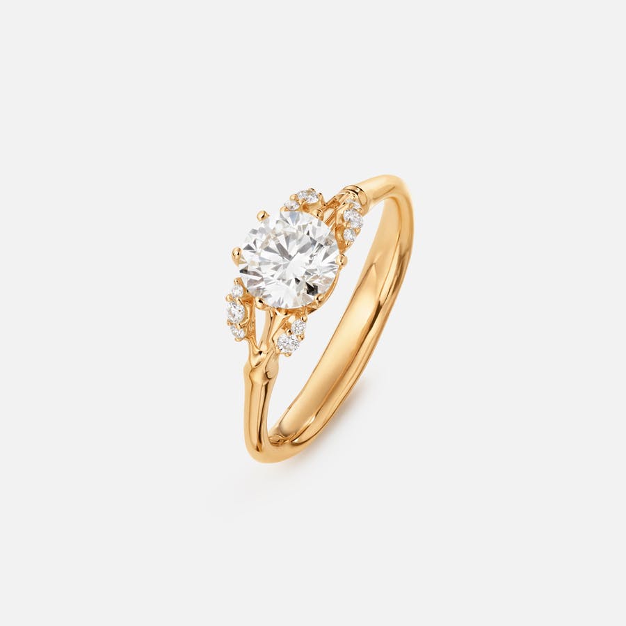 Winter Frost Solitaire Ring aus 18 Karat Gold mit einem Diamanten im Brillantschliff und 10 kleinen, weißen Diamanten auf 4 kleinen Blättern | Ole Lynggaard Copenhagen